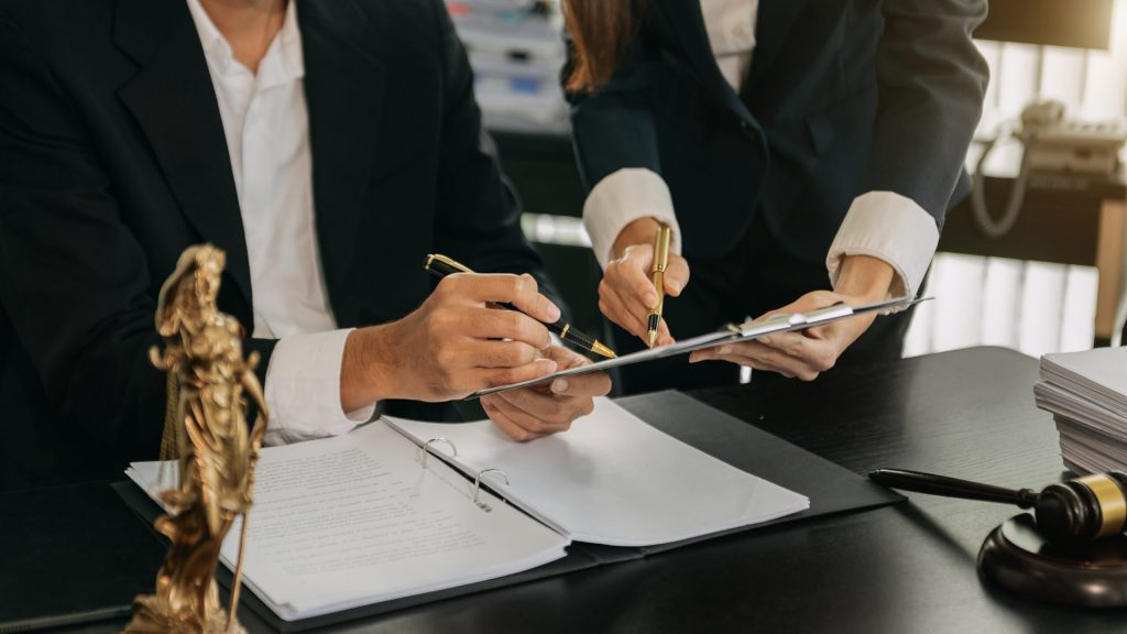 business people and lawyers discussing contract papers sitting a